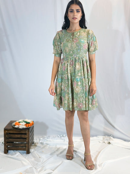 Woman wearing a floral dress standing against a plain background