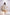 Woman wearing a white pleated dress in a minimalistic setting. Freo