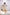 Woman wearing a white pleated dress in a minimalistic setting. Freo