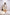 Woman wearing a white pleated dress in a minimalistic setting. Freo