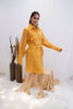 Woman wearing a yellow outfit standing in a minimalistic setting with white background and decorative elements. Freo